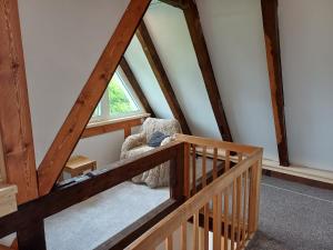 an attic room with a crib and a window at Chaloupka na vršku in Loučná pod Klínovcem