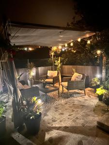 a patio with couches and chairs under a canopy at night at maderedocevida in Boaventura