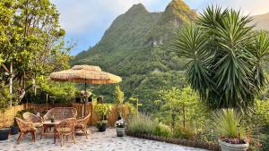 a patio with a table and chairs and a mountain at maderedocevida in Boaventura