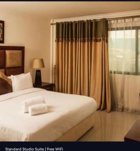a bedroom with a large bed and a window at Agentour Guesthouses in Luanda +33 photos