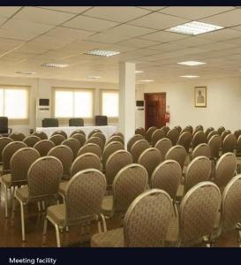 a room with rows of chairs and a table at Agentour Guesthouses in Luanda