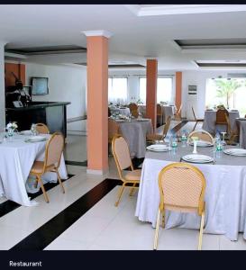 a dining room with tables and chairs with white table cloth at Agentour Guesthouses in Luanda
