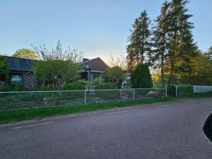 a fence in front of a house with a yard at Sandmo Holiday Home 11 in Eckerö
