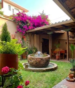 a garden with a fountain in the yard at Hotel Ines Maria in Cuenca