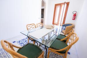 ein Esszimmer mit einem Glastisch und Stühlen in der Unterkunft Il quadrifoglio home in Marettimo + 24 Fotos