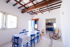 eine Küche und ein Esszimmer mit Tisch und Stühlen in der Unterkunft Il quadrifoglio home in Marettimo
