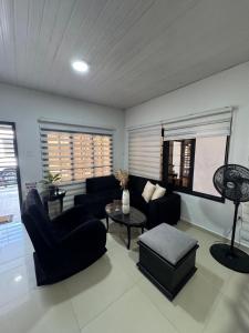 a living room with a couch and a table at Casa bonita y cómoda con antejardín Barrio Jardín 2-4 personas in Leticia