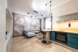 a kitchen with blue cabinets and a living room at Arthur's Home in Miskolc