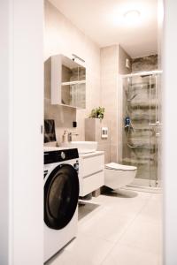 a bathroom with a sink and a washing machine at Zs Apartment in Tuzla +9 photos