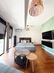 a bedroom with a bed and a table and a tv at Zs Apartment in Tuzla