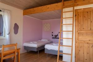 a bedroom with two bunk beds and a ladder at Visitor Stugby in Håverud
