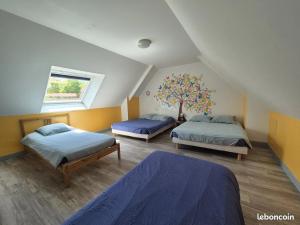 a bedroom with two beds and a tree on the wall at Gîte Le petit Fresnay in Le Bourgneuf-la-Forêt +6 photos