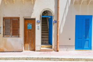 ein Gebäude mit blauen Türen an der Seite in der Unterkunft Il quadrifoglio home in Marettimo
