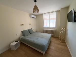 a small bedroom with a bed and a window at Meublé de Tourisme Le Swing in Marsannay-la-Côte