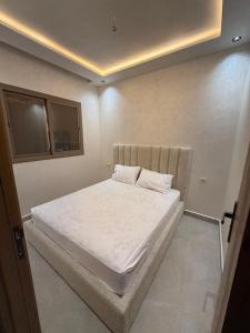 a small bedroom with a bed with white sheets at اقامة هبة 6 in Yebha