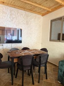 a dining room with a wooden table and chairs at اقامة هبة 6 in Yebha