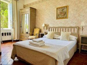 a bedroom with a large bed with towels on it at Hôtel Le Siècle in Mazan