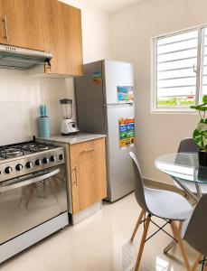 a kitchen with a stainless steel refrigerator and a table at Tropical Pearl Getaway in Los Paredones +10 photos