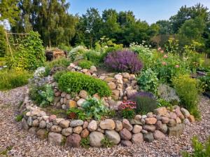 a garden with a circle of rocks and flowers at Langeland Glamping in Rudkøbing