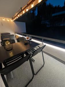 a table and chairs on a balcony at night at Ferienwohnung Flumserberg, Liftnähe & Gratis Parkplatz in Flumserberg