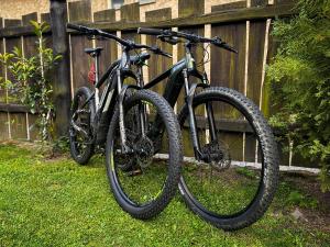 two bikes are parked next to a fence at Chata pri Kaštieli - 2 E-bikes in Necpaly