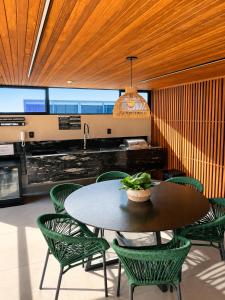 a dining room with a table and green chairs at Hit Cabo Branco by 123Quarto in João Pessoa
