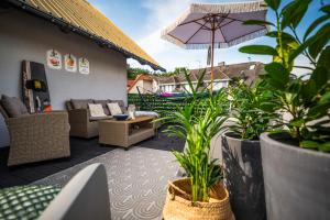 an outdoor patio with plants and an umbrella at DOM GOŚCINNY ROMA in Rewal