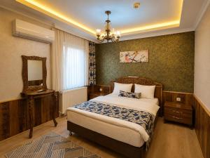 a bedroom with a bed and a mirror and a chandelier at ECRİN OTEL in Uzungöl