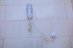 a blue hairdryer hanging on a wall at ExtraMile Apartments - 2BR-R in Dodoma +38 photos