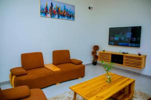 a living room with two couches and a tv at ExtraMile Apartments - 2BR-R in Dodoma