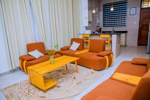 a living room with orange chairs and a coffee table at ExtraMile Apartments - 2BR-R in Dodoma