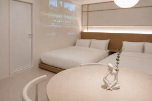 a room with two beds and a table with a statue at 윤스테이 행궁 호텔-Yoonstay Haenggung in Suwon