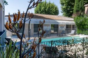 a house with a fence and a swimming pool at Hotel Cantosorgue in L'Isle-sur-la-Sorgue