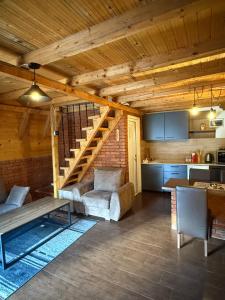a living room with a staircase and a kitchen at STANET Forest Houses in Novoberdo