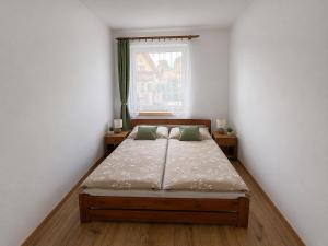 a bed in a room with a window at Domček u Alberta in Vrbov