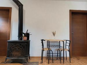a table and chairs and a stove in a room at Domček u Alberta in Vrbov