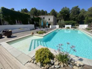 a swimming pool in a yard with chairs around it at Gîte Carcassonne le Relais de la Cavayere in Carcassonne