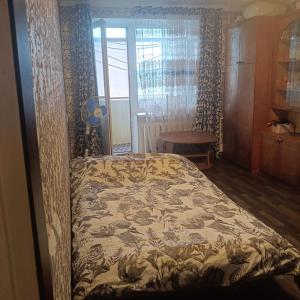 a bedroom with a bed with a floral bedspread at Квартира in Sumy
