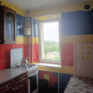 a kitchen with a stove and a window at Квартира in Sumy +2 photos