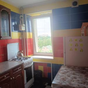 a kitchen with a stove and a window at Квартира in Sumy