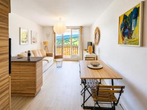 a living room with a table and a couch at Le Balcon de Corrençon - Les Moucherolles in Corrençon-en-Vercors