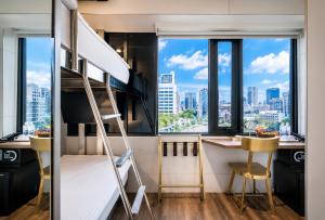 a bedroom with a bunk bed and a desk with a view of the city at Hotel Relax 5 in Taipei
