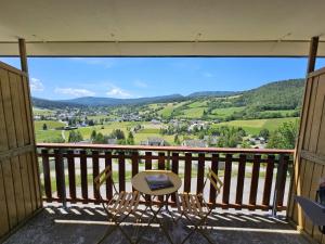 a balcony with chairs and a view of a valley at Le Balcon de Corrençon - Les Moucherolles in Corrençon-en-Vercors