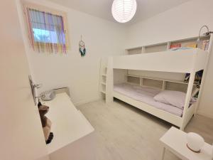 a white bunk bed in a room with a dog at Le Balcon de Corrençon - Les Moucherolles in Corrençon-en-Vercors