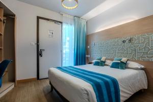 a bedroom with a large bed with blue pillows at Hotel Cantosorgue in L'Isle-sur-la-Sorgue +41 photos
