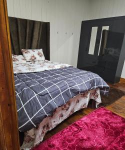 a bedroom with a bed and a mirror and a pink rug at Blessed home by the Mountain surrounded macadamia in Barberton