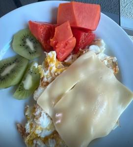 a plate of food with fruit and cream on it at Pousada Maria Bonita - Centro, 10min da Praia de Camapum, Macau RN in Macau