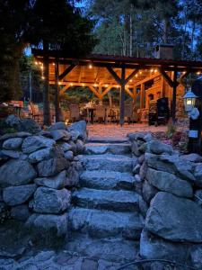 a stone path in front of a wooden cabin at Ostrzyce Park in Ostrzyce
