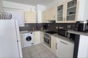 a kitchen with white cabinets and a washer and dryer at Spacious apartment in La Teste-de-Buch in La Teste-de-Buch
