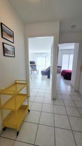 a living room with a tiled floor and a yellow shelf at Spacious apartment in La Teste-de-Buch in La Teste-de-Buch